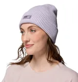 Gorro tipo beanie de punto acanalado en color lavanda, con parche de la marca Columbia en el frente.