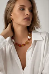 Collar elaborado con cristales checos facetados en tonos rojo, ámbar, blanco y transparente, con dijes en forma de corazón y cierre de acero.