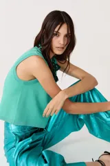 Top tejido de punto color turquesa con lúrex, sin mangas y cuello a la base.