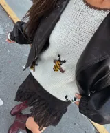 Buzo tejido a mano en lana merino, color blanco con diseño estampado de abejas en tonos amarillo, negro y marrón. Presenta cuello redondo y mangas largas con ajuste holgado.