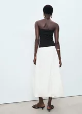Vestido midi combinado con cuerpo palabra de honor negro de tejido elástico y falda blanca abullonada de estilo globo en algodón.