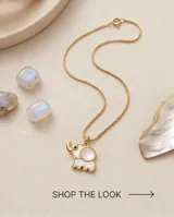 Collar de bronce dorado con cadena fina y dije en forma de elefante con incrustación de nácar blanco.