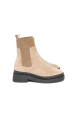 Bota estilo Chelsea de gamuza color avena, con paneles elásticos laterales al tono y suela chunky de goma negra.