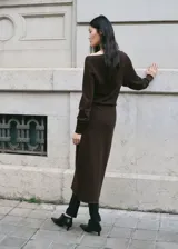 Vestido midi de punto color marrón, con escote bote caído, manga larga y tajo lateral en la falda.