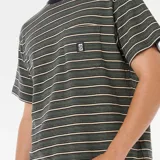 Remera de manga corta Rip Curl Search Stripe Tee, a rayas horizontales en tonos verde oliva, beige y negro. Tiene cuello redondo y bolsillo en el pecho con logo de la marca.