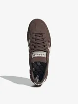 Championes Adidas Handball Spezial, color marrón con detalles de textura animal print en las icónicas tres tiras y en el talón. Presenta el nombre del modelo estampado en dorado en el lateral y suela de goma semitransparente.