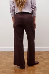 Pantalon de corte recto y tiro alto, confeccionado en un tejido de acabado suave y textura aterciopelada, con costuras verticales decorativas en el frente.