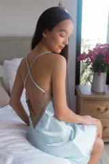 Camisón de satén elastizado color celeste, con escote en V con detalle de puntilla blanca y breteles finos cruzados en la espalda.