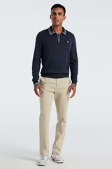Sweater de punto color azul marino, con cuello polo, cierre frontal parcial y detalles de rayas blancas en el cuello y puños. Presenta el logo de la marca bordado en el pecho.