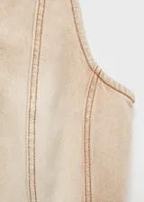 Top corto color beige con cierre frontal con cremallera, cuello redondo, sin mangas y costuras decorativas. Diseño entallado de algodón estilo tejano vaquero.