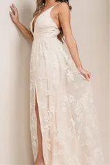 Vestido largo de fiesta con escote en V profundo, tirantes finos y falda con tajo lateral. Confeccionado en tela con brillos y detalles de encaje bordado en toda la prenda.