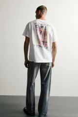 Camiseta relaxed fit de color blanco con efecto lavado, cuello redondo y manga corta. Presenta un pequeño estampado a contraste en el pecho izquierdo.