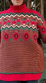 Buzo de punto grueso con cuello alto y diseño jacquard que presenta motivos de granjeros, casas y árboles en tonos crema, marrón, rojo y amarillo.