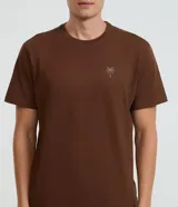 Remera de corte comfort, color marrón, con cuello redondo, manga corta y estampa localizada de palmera en el pecho.