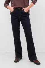 Pantalón tipo jean de corte recto y tiro medio, color burdeos, con costuras a tono y abertura lateral en el ruedo.