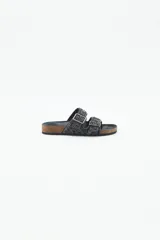 Sandalia baja abierta de estilo 'slide' con dos tiras ajustables con hebillas metálicas. Las tiras están completamente decoradas con bordados de mostacillas, canutillos y strass en tonos negros y grises. La plantilla es de corcho visible forrada en cuero negro, y la suela es de goma.