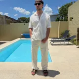 Pantalón cargo de lino color blanco, corte holgado (oversize), con cordón ajustable en la cintura y bolsillo cargo con etiqueta en el lateral del muslo.