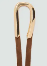 Cinturón fino de cuero marrón con hebilla metálica dorada de diseño alargado y cierre de nudo.