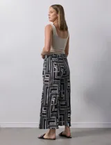 Pantalón ancho estilo palazzo, de seda fría plisada con estampado geométrico en negro, blanco y beige. Tiene pretina ancha elastizada y largo crop.