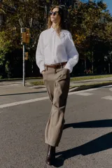 Camisa de corte amplio y estilo oversize, confeccionada en tejido tipo Oxford. Presenta cuello solapa con botones, cierre frontal abotonado, mangas largas con puños estructurados y bajo asimétrico.
