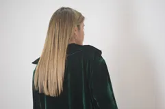 Campera verde inglés de terciopelo con cierre dorado, mangas abullonadas y puños elastizados.
