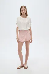 Short pollera color rosa viejo, de diseño cruzado tipo envolvente con detalle de botones laterales.