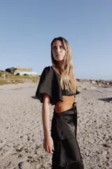 Vestido largo de dos piezas color lila con rayas verticales. El top es de corte cuadrado con mangas cortas acampanadas y elástico en la cintura. La falda es larga con volados y detalles de cuero.