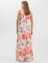 Vestido largo de chifón plisado con estampado floral en tonos rojos y grises sobre fondo blanco. Presenta escote en V pronunciado con panel de microtul, cintura drapeada con nudo central y falda amplia con capa frontal asimétrica. Incluye forro interior y cierre invisible en la espalda.
