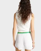 Short blanco con cintura elástica y ribete verde. Cuenta con bolsillos laterales y logo bordado en la pierna izquierda. Fabricado en poliéster COOLMAX.