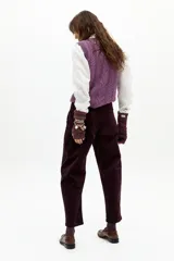 Pantalón de corduroy color berenjena, de corte barrel relajado, tiro medio, cierre frontal, bolsillos laterales y amplios bolsillos traseros.