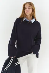 Buzo de punto fino color azul marino, con cuello redondo, hombros caídos y remates acanalados en puños y bajo.
