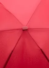 Paraguas plegable de tamaño mini en color rojo, con diseño liso y correa de mano a juego. Incluye un cierre metálico a presión con detalle de logo grabado.