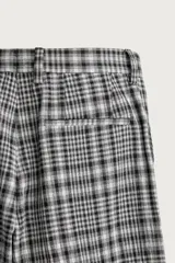 Pantalón flare fit confeccionado en tejido con algodón, con estampado a cuadros en tonos grises y negros. Cuenta con bolsillos laterales, bolsillos traseros de vivo y cierre frontal con cremallera y botón.