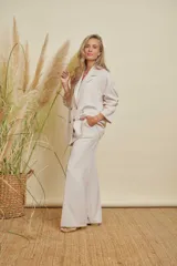Pantalón sastrero de pierna recta color beige, con bolsillos traseros simulados y trabillas para cinturón.