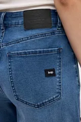 Jean de tiro medio con corte wide leg y diseño de pierna extra ancha. Presenta un lavado azul profundo y ruedo deshilachado.