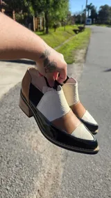 Zapatos de cuero negro con paneles texturizados, punta fina, taco cuadrado y elásticos laterales para mayor comodidad.
