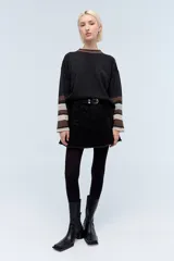 Minifalda negra tableada con costuras a contratono en azul y hotfix en tonos de negro, grises y azul.