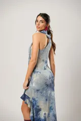 Vestido corto con estampado abstracto en tonos azules y beige. Presenta escote halter con pañuelo al cuello, corte irregular y ruedo con volados.