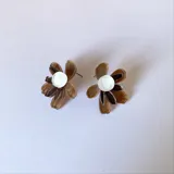 Aros tipo botón con forma de flor de pétalos turquesa y centro rosa y naranja.