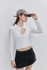 Top de calce al cuerpo color negro, confeccionado en tejido elástico con textura acanalada, con cuello camisero, mangas largas y recorte frontal tipo cut-out.
