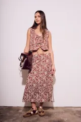 Chaleco marrón con estampado de hojas blancas, escote en V y lazos ajustables en el frente.