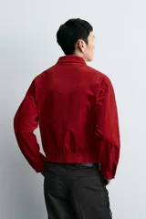 Sobrecamisa de corte boxy fit confeccionada en tejido de pana de algodón con elasticidad. Presenta cuello solapa, cierre frontal con cremallera, mangas largas con puños abotonados y dos bolsillos de plastrón con solapa en el pecho.