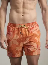 Short de baño con estampado botánico en tonos naranja y coral, con cintura elástica ajustable mediante cordón y malla interior para mayor soporte.