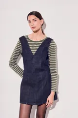 Vestido jumper corto de jean azul oscuro, con escote en V y breteles anchos.