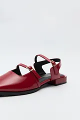 Zuecos destalonados color crema, de símil cuero, con punta cuadrada y finas tiras con hebillas ajustables. Cuentan con taco de 2,5cm de alto.