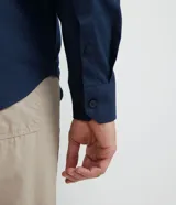 Camisa de vestir azul marino, corte slim fit, de tela Oxford, con cuello camisero y cierre con botones.