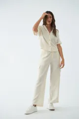 Pantalón cargo de tiro alto y corte recto, confeccionado en viscosa con textura arrugada. Cuenta con bolsillos laterales, cierre de cremallera y botones, y presillas para cinturón.