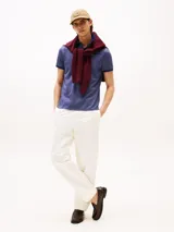 Chomba azul con tejido jacquard, cuello tipo chomba, cartera de dos botones y logo de Tommy Hilfiger bordado en la manga.