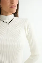 Polera de tejido de punto acanalado en color gris oscuro, con cuello alto y mangas largas ajustadas.