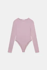 Body de poliamida color rosado, de manga larga, con cuello redondo y cierre inferior con botones a presión.